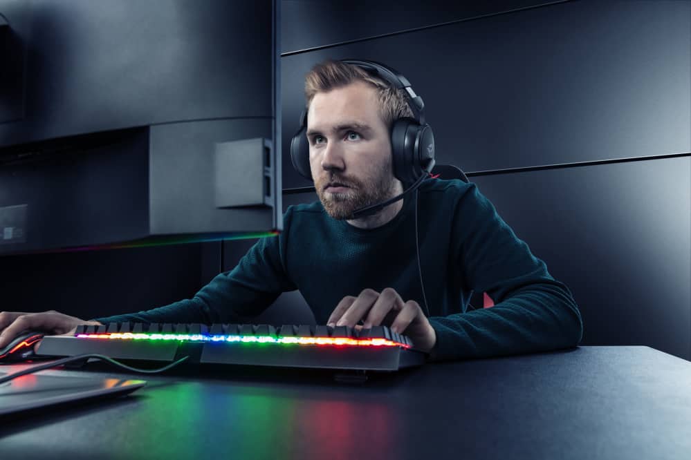 homem branco jogando no computador com headset nos ouvidos