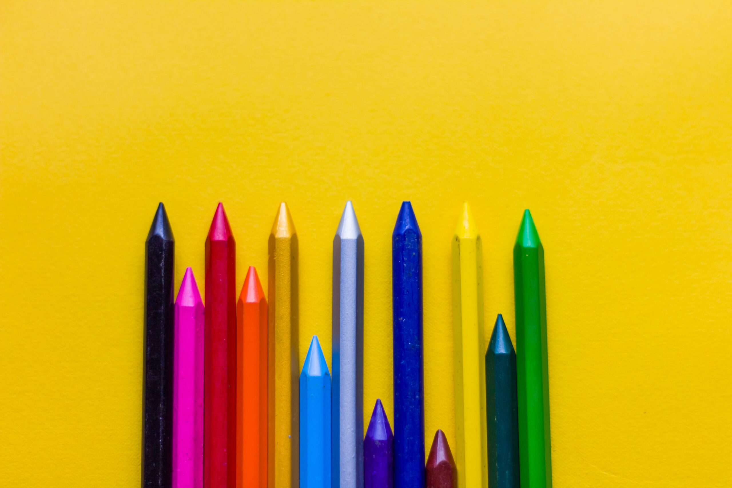 Giz de cera coloridos em um fundo amarelo